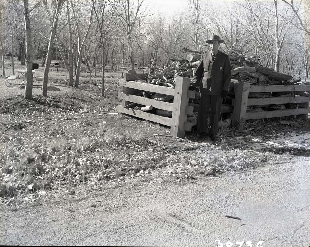Site of visitor accident, location of wood rack and truck. Ranger standing by wood rack.