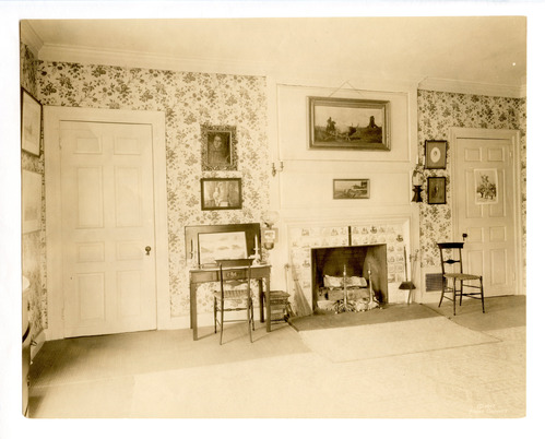 Black and white photograph of 19th century bedroom with fireplace.