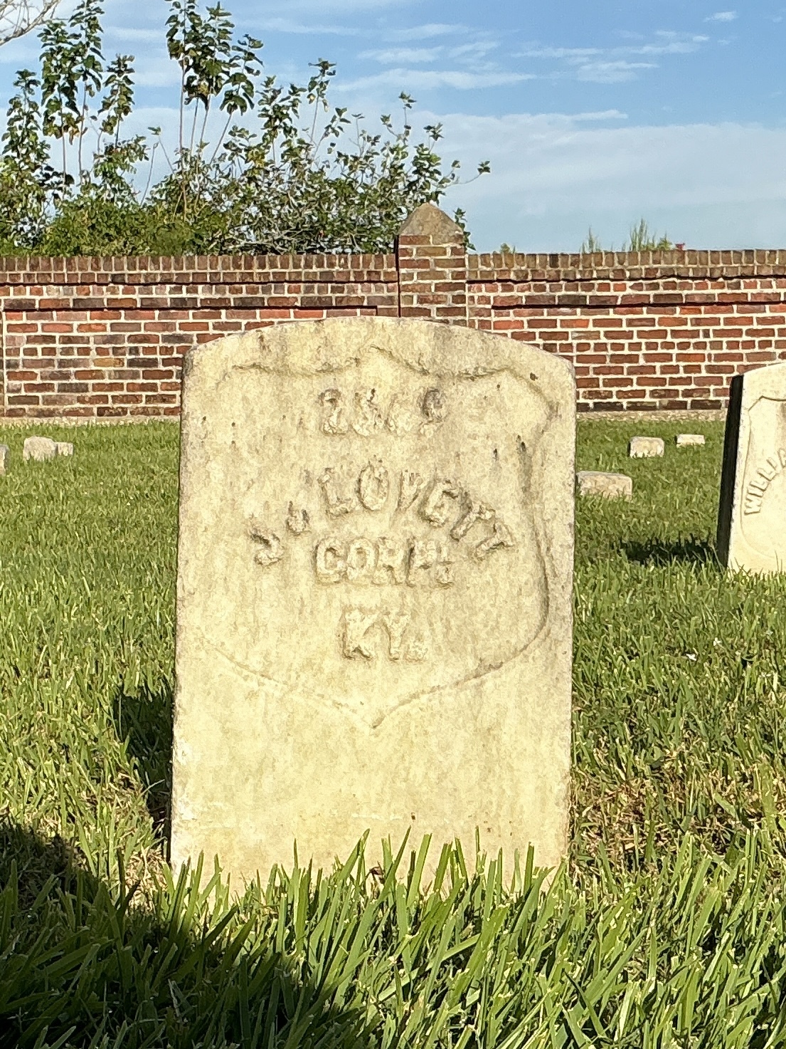 Front of historic upright marble headstone with recessed shield face.