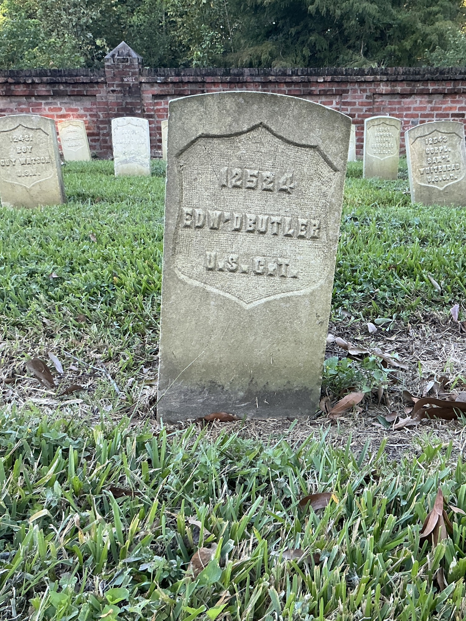Front of historic upright marble headstone with recessed shield face.