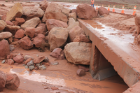  Photograph of boulders and mud covering the road to Lees Ferry following the September 2013 flood. Boulders are large, up to car sized. 