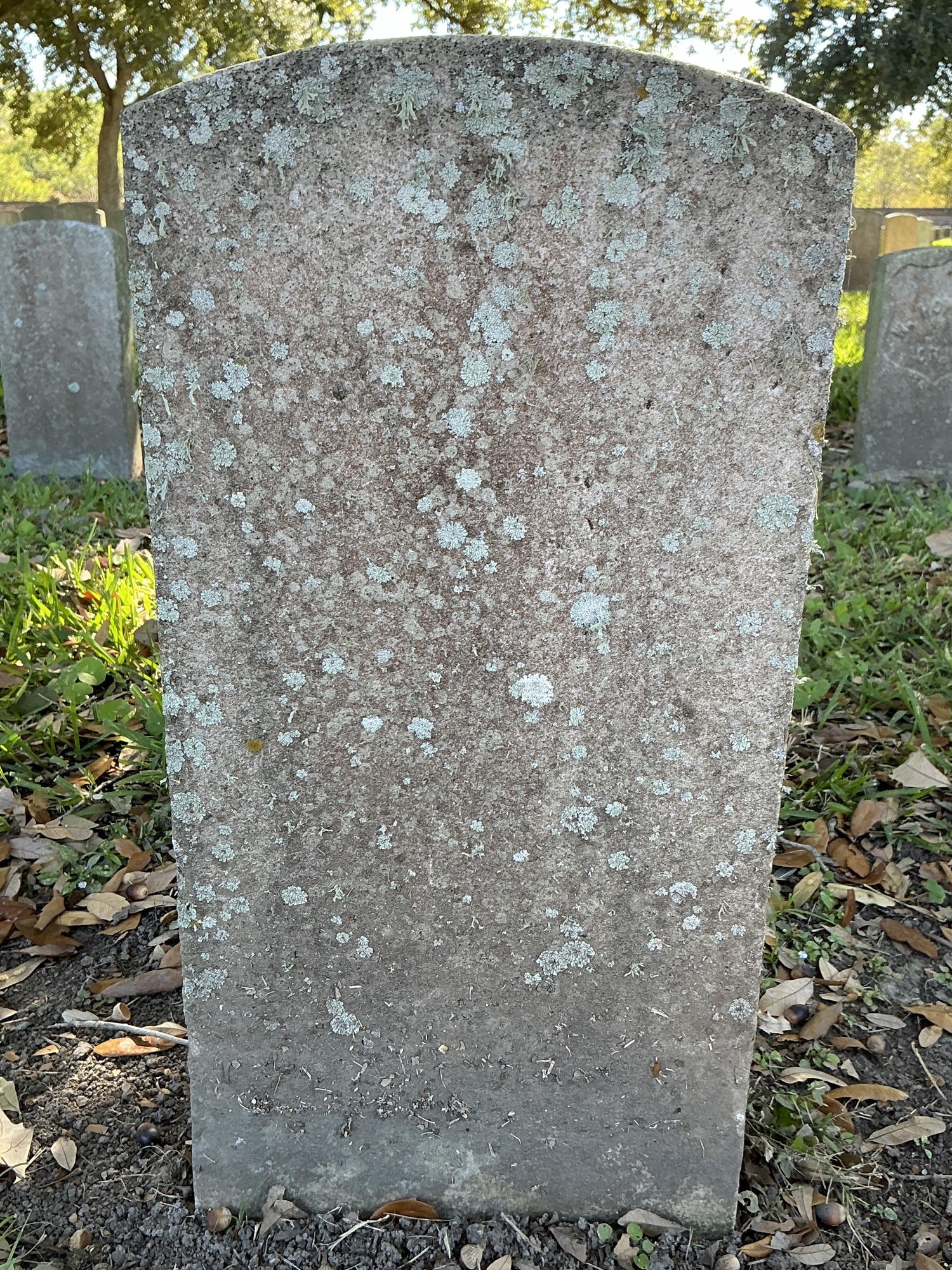 Back of historic upright marble headstone with recessed shield face.