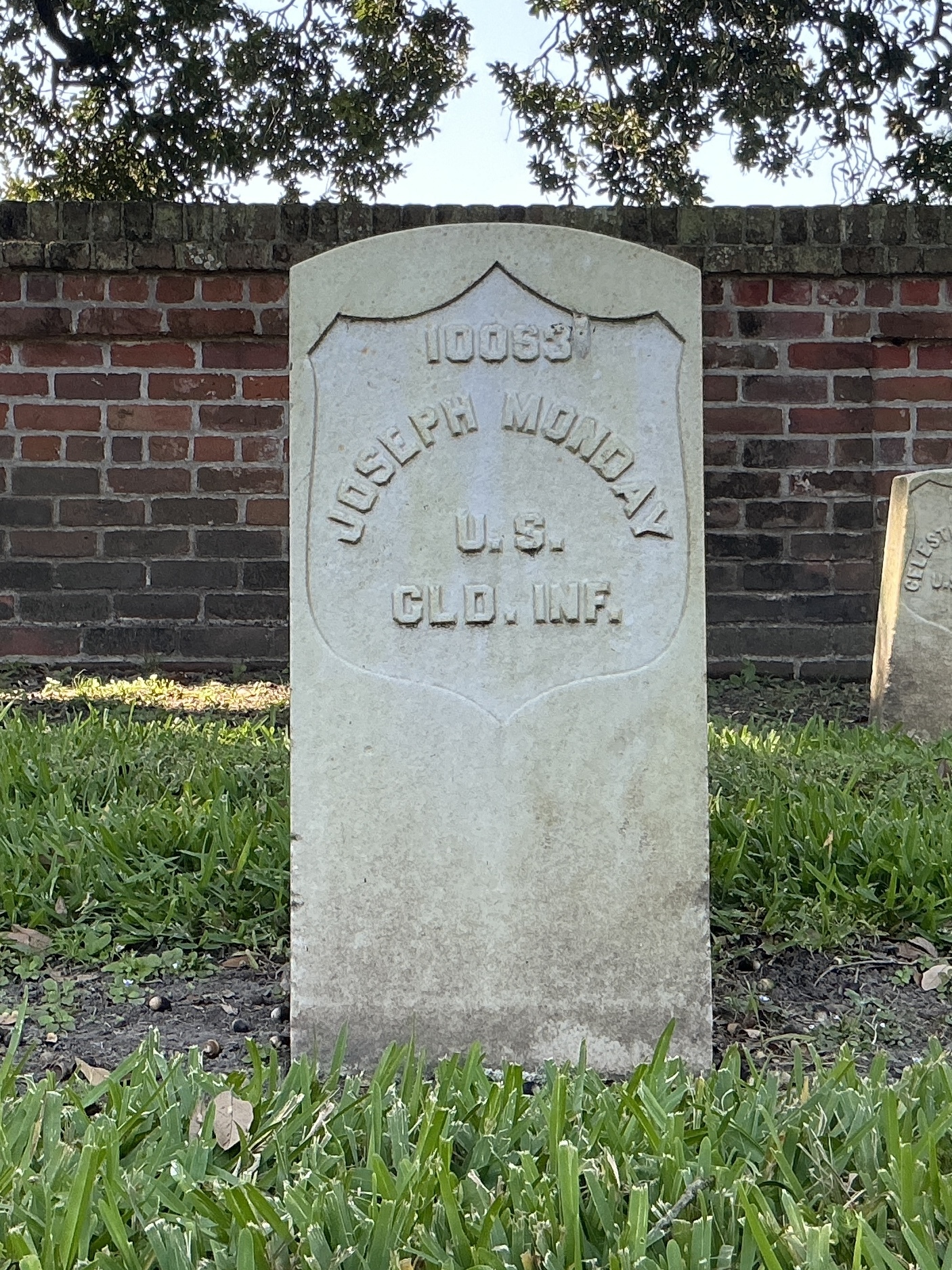 Front of historic upright marble headstone with recessed shield face.