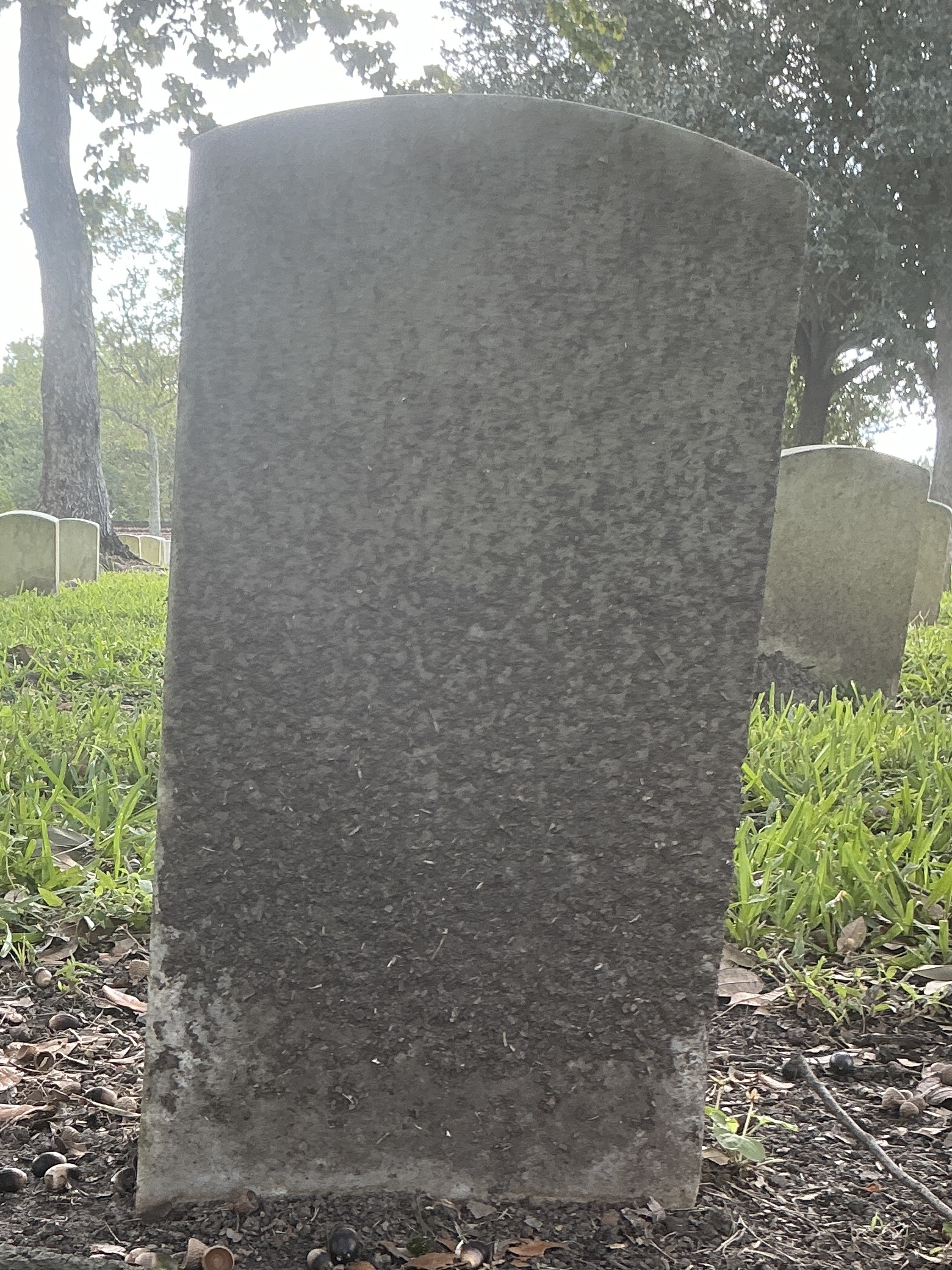 Back of historic upright marble headstone with recessed shield with recessed lettering face.