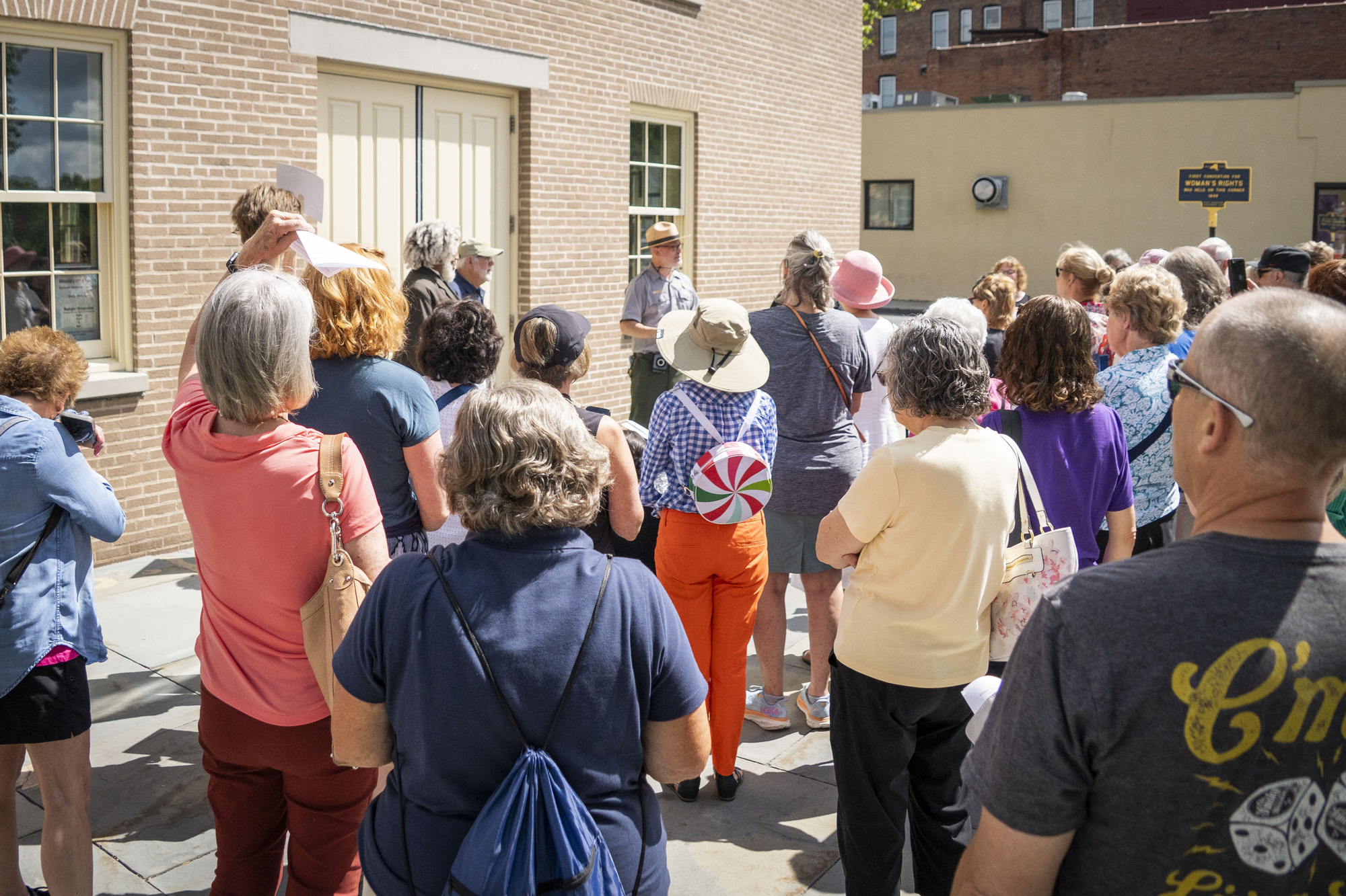 A group of people gather in front of a brick building