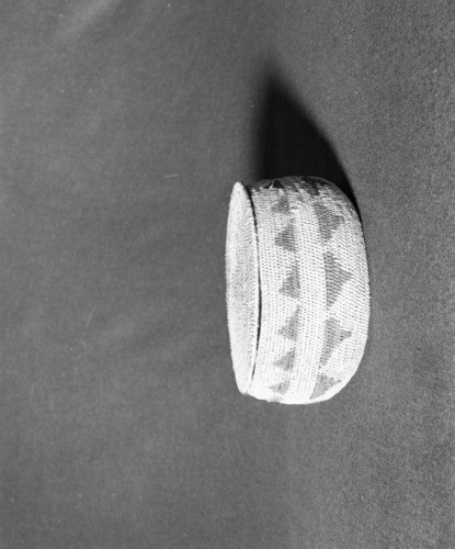 Marie Rozier Collection, Catalog No. 51. Object: Miwok basket. Dimensions: 8 x 4". Materials: bull pine, fern root. Technology: single rod; leftward coil direction; fag ends trimmed on exterior; moving ends trimmed on interior; flat disc lid. Collection History: made on Tuolumne Rancheria for Mary Long on order in 1930. Photographed by Michael Dixon, December 1982. Catalogued by Craig Bates and Barbara Beroza. Yosemite Collections, National Park Service.