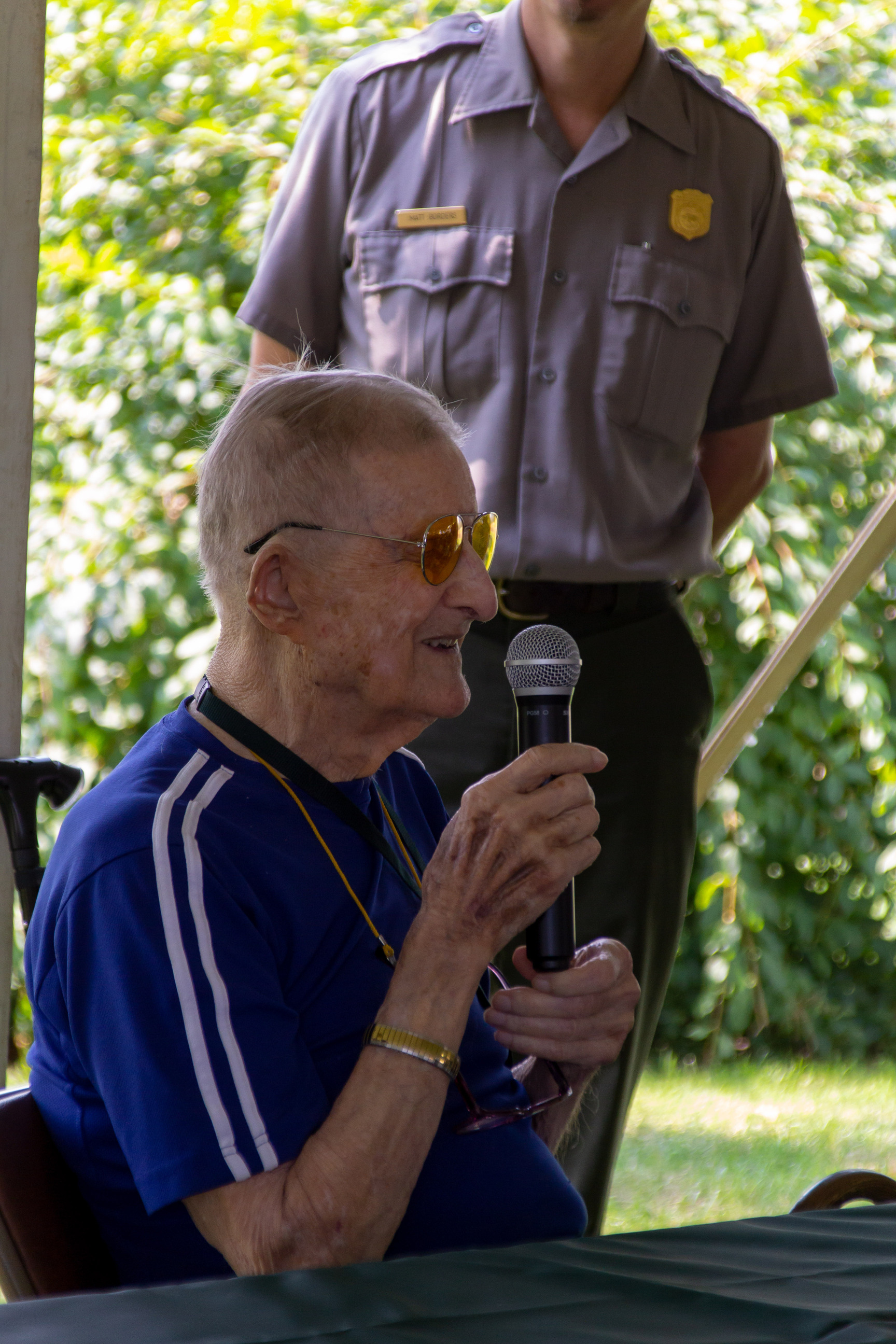 WWII veteran speaking in to a microphone.