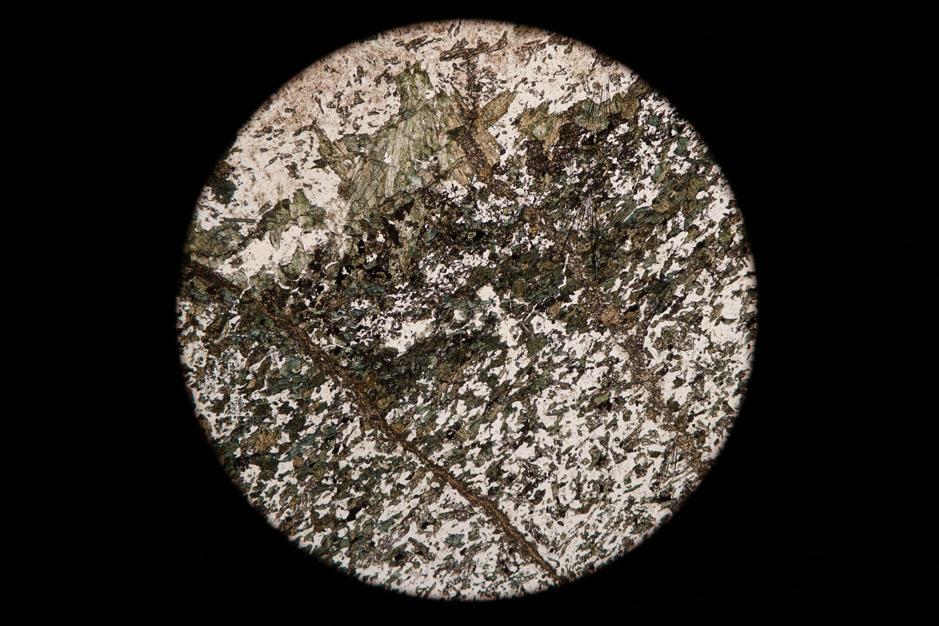 Circular microscopic image of rock structure.