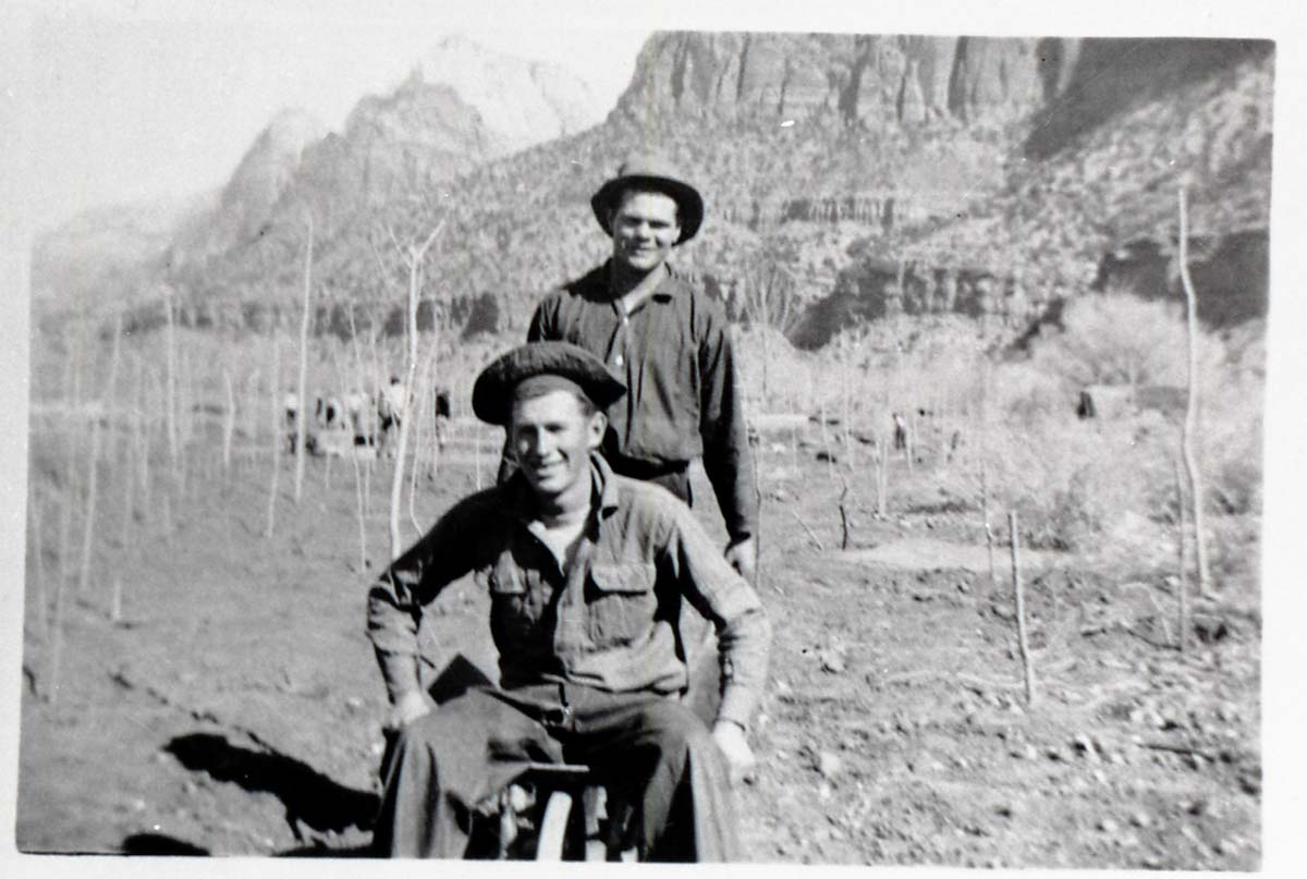 Two Civilian Conservation Corps (CCC) men riding in wheel barrow near the South Entrance.