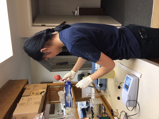 A volunteer uses water quality equipment to test a sample in a lab.