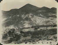 This is an historic black and white photograph from the Scotty's Castle Historic Photograph Collection, Death Valley National Park of Upper Grapevine Ranch looking north from a distance at Scotty's Castle Stables and Garage / Long Shed / Bunkhouse. May 1931. Photographed by Mat Roy Thompson.