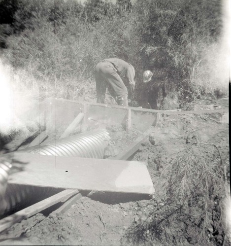 Park personnel installing a culvert/drainage pipe in location in Zion.