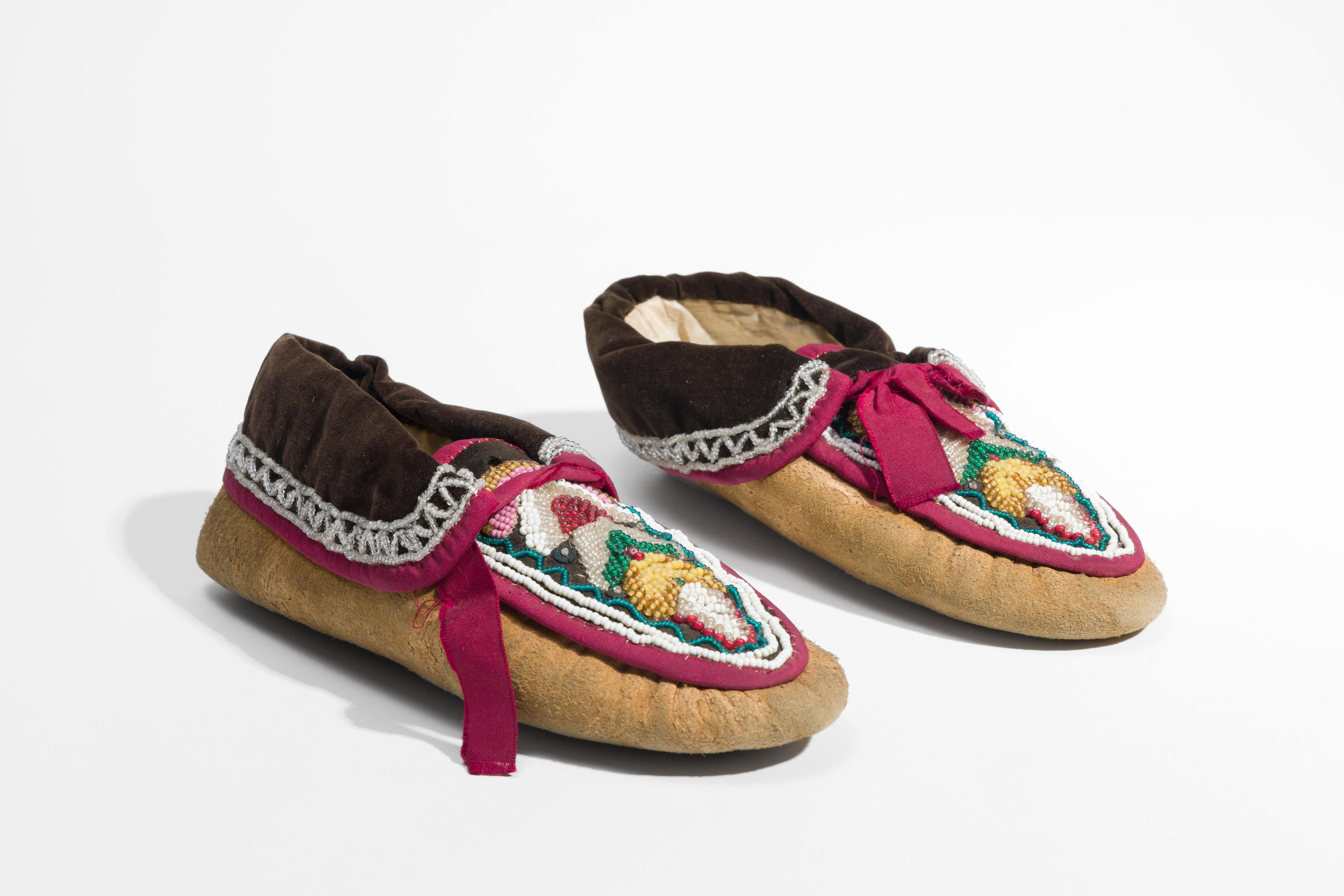 Pair of moccasins with multi-colored beaded designs and velvet cuffs.