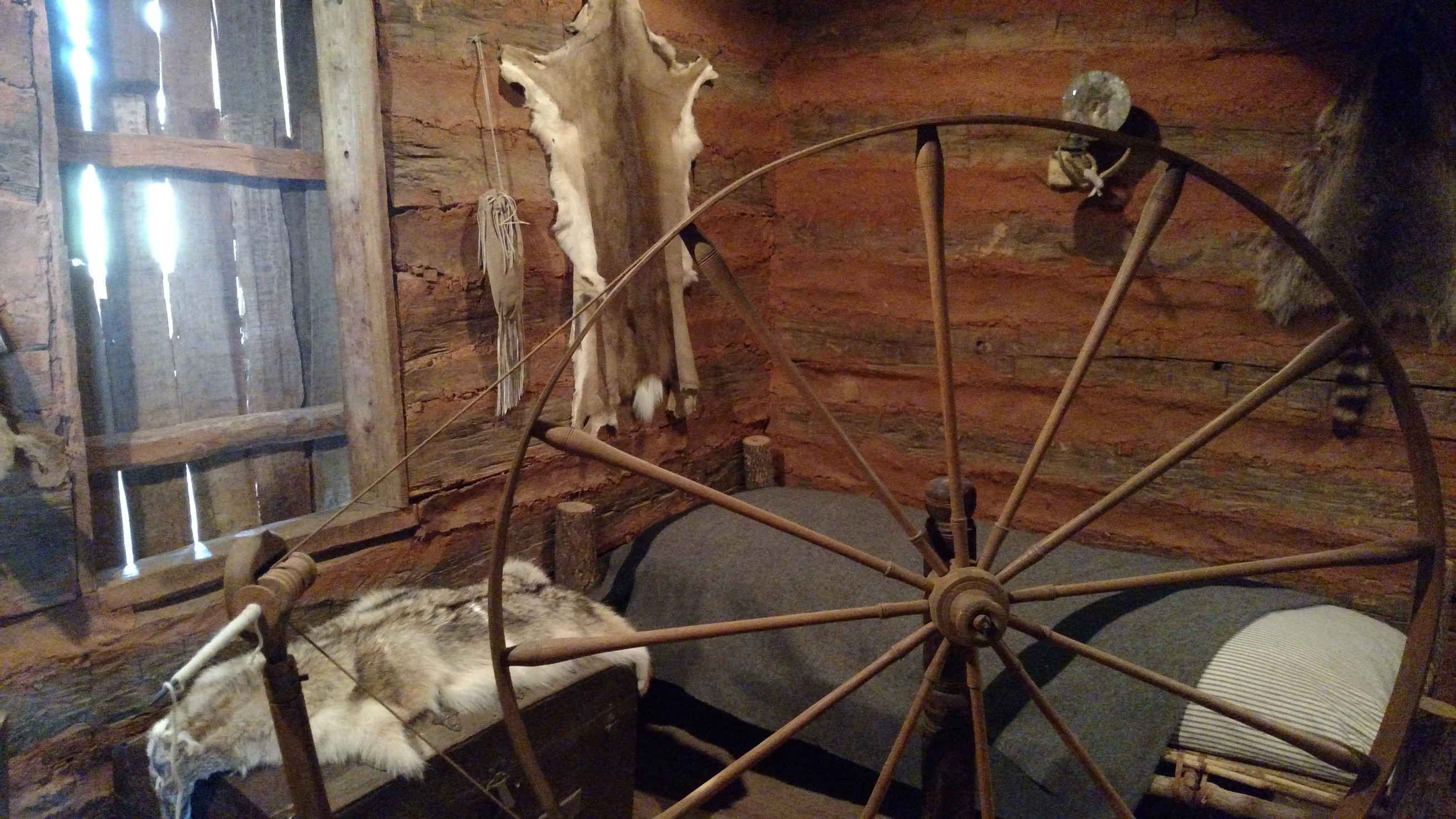 A wooden bed in a log cabin.