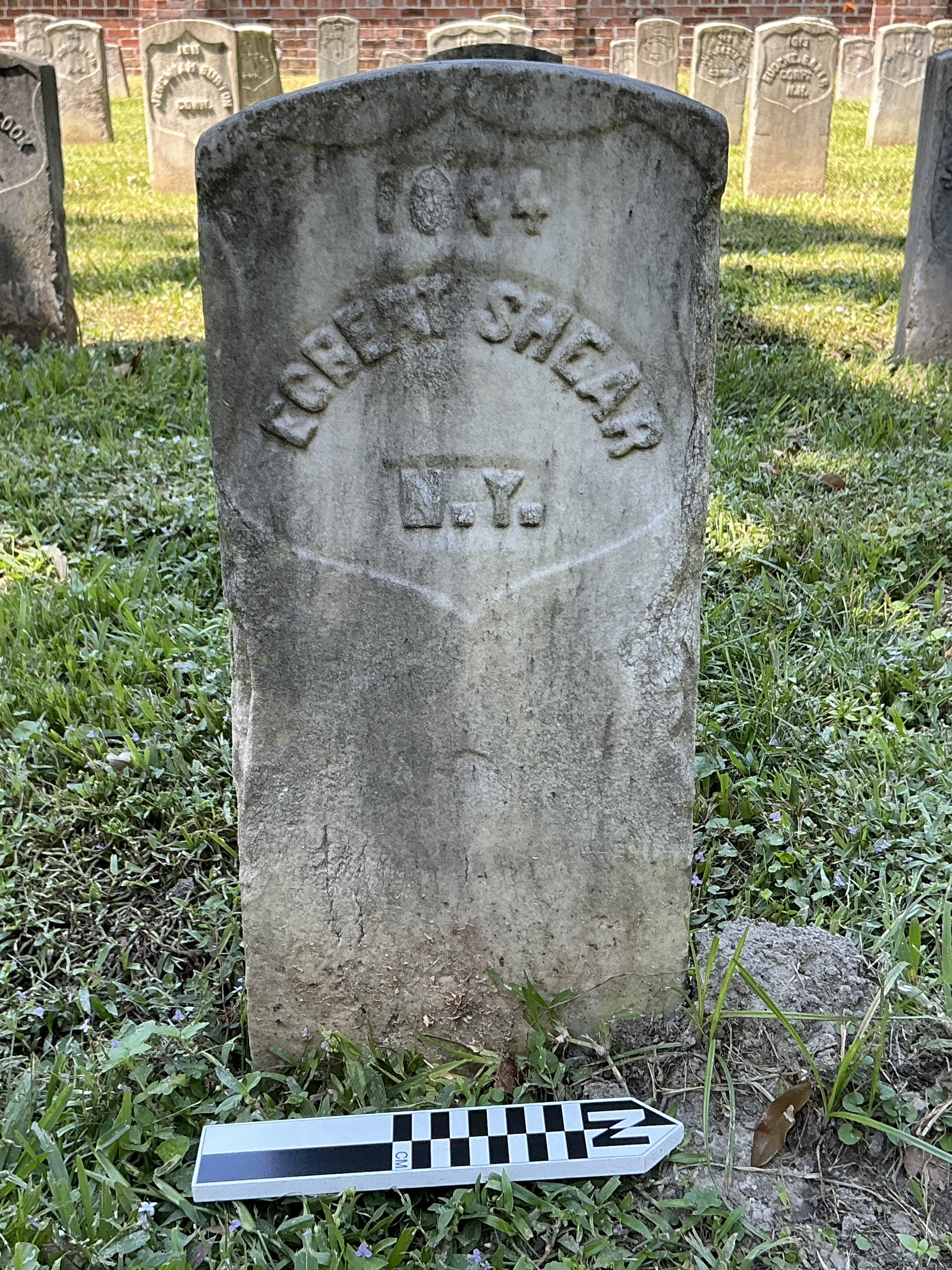 Extra image of historic upright marble headstone with recessed shield with recessed lettering face.