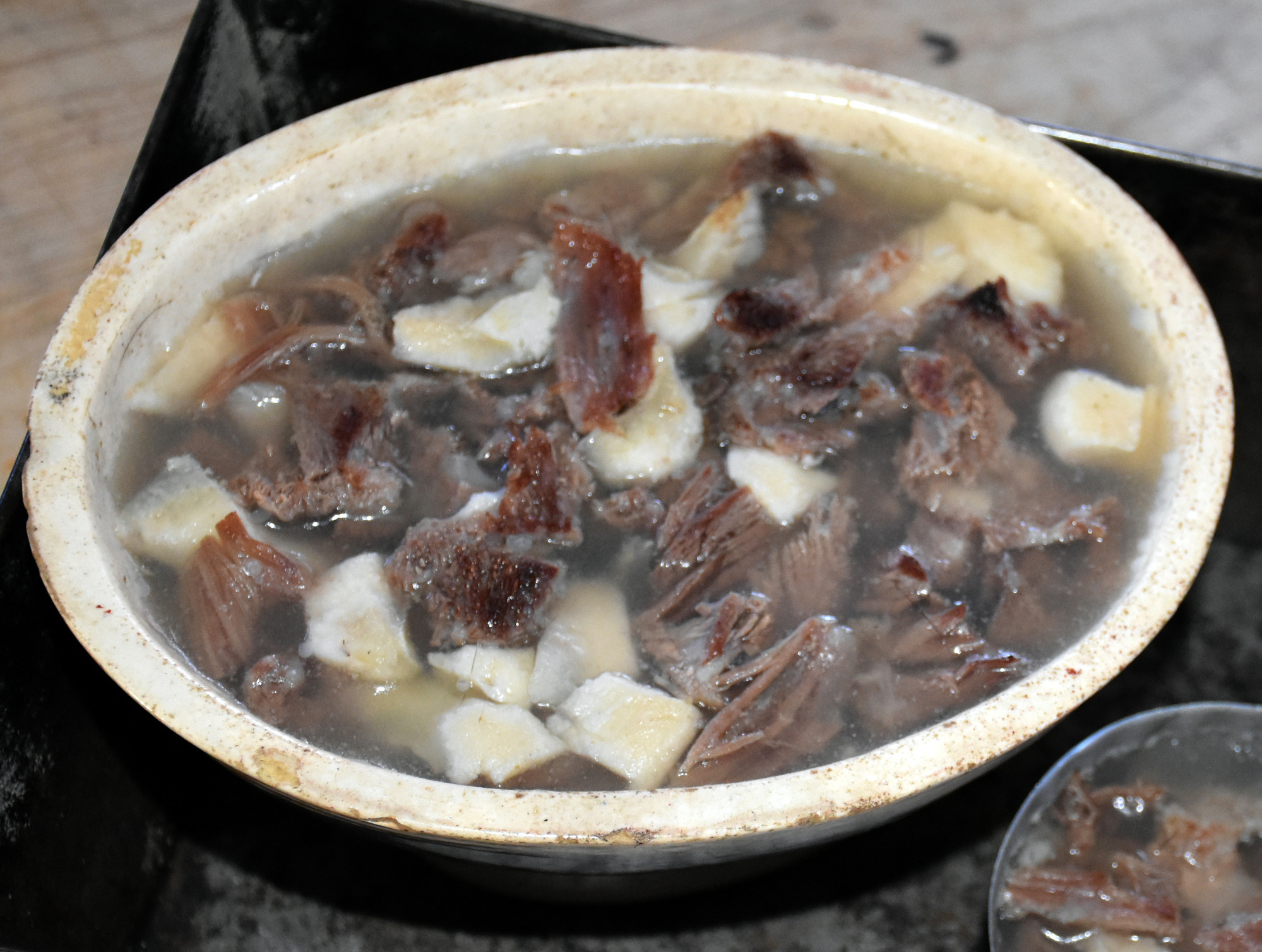 Oval shaped dish with chopped me and turnip pieces in gelatin.