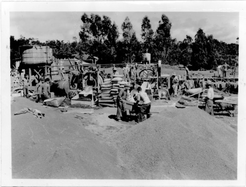 Black and white. A group of men pouring conrete 