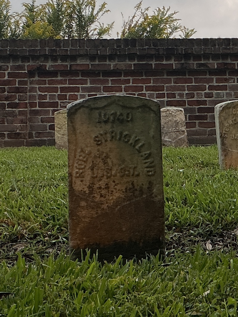 Front of historic upright marble headstone with recessed shield face.