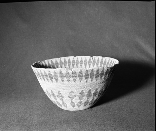 Marie Rozier Collection, Catalog No. 2. Object: Miwok cooking basket. Dimensions: 15 x 8 1/4". Materials: Bracken fern, unidentified split shoot, (possibly maple). Technology: 3 rod foundation, spaced stitching, fag ends trimmed on work face, moving ends trimmed on interior, leftward coil direction, clockspring start with 1/4" diameter hole remaining. Rim finish nearly gone but of slanted type. Never used. Collection History: Bought from Evelena Cox in Tuolumne about 1910 by Annie Teague. Photographed by Michael Dixon in December 1982. Photographed by Michael Dixon in December 1982. Catalogued by Craig Bates and Barbara Beroza. Yosemite Collections, National Park Service.