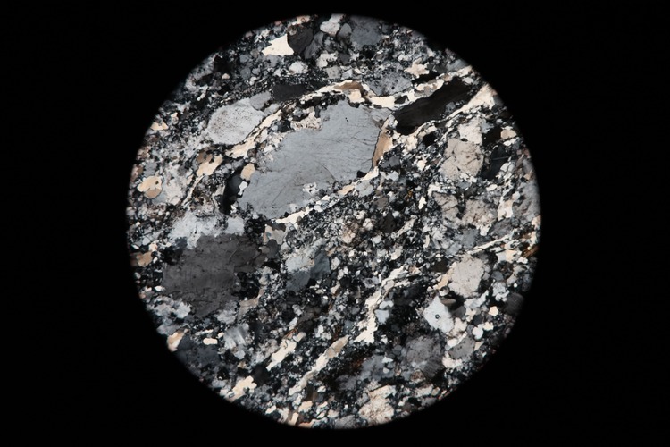 Circular microscopic image of rock structure.