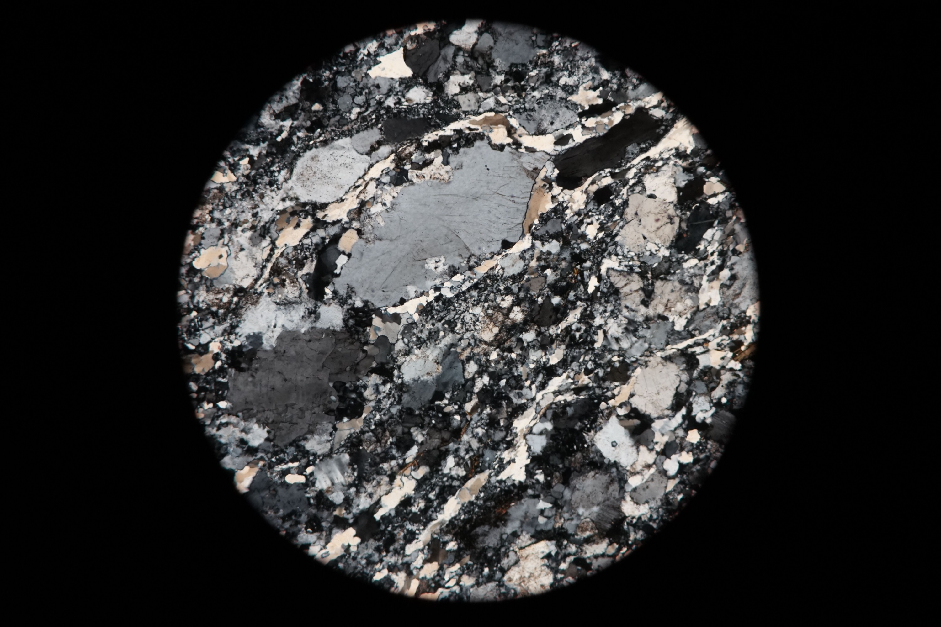 Circular microscopic image of rock structure.