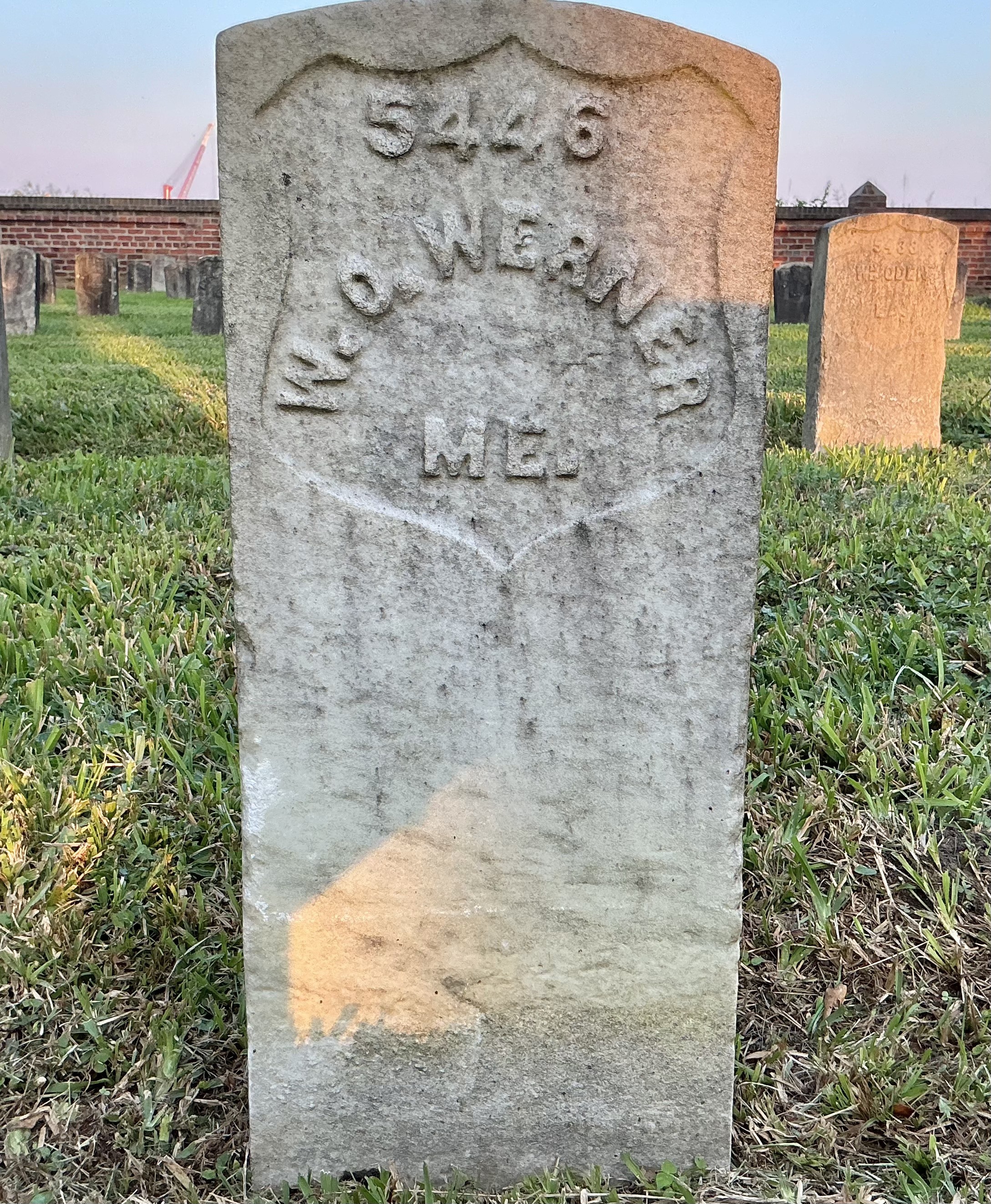 Front of historic upright marble headstone with recessed shield face.