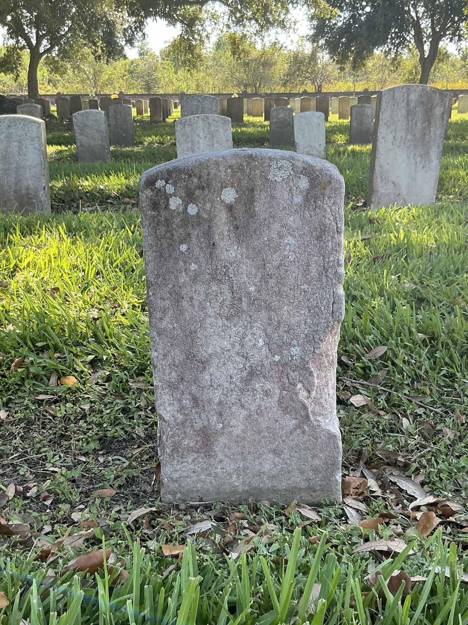 Back of historic upright marble headstone with recessed shield with recessed lettering face.