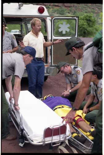 Color photo of SAR team transporting injured man.