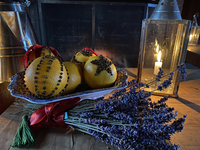 Pomanders with stripes and shapes of cloves displayed on a plate.