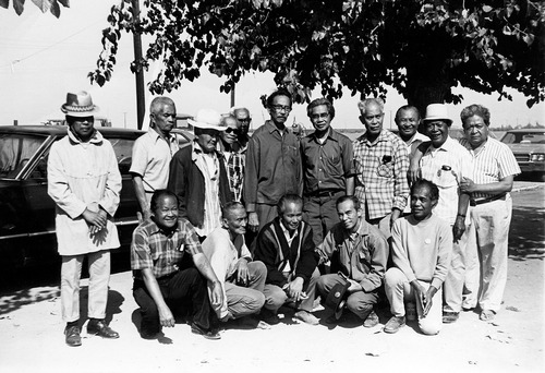 A black and white photo of a group of 16 men.