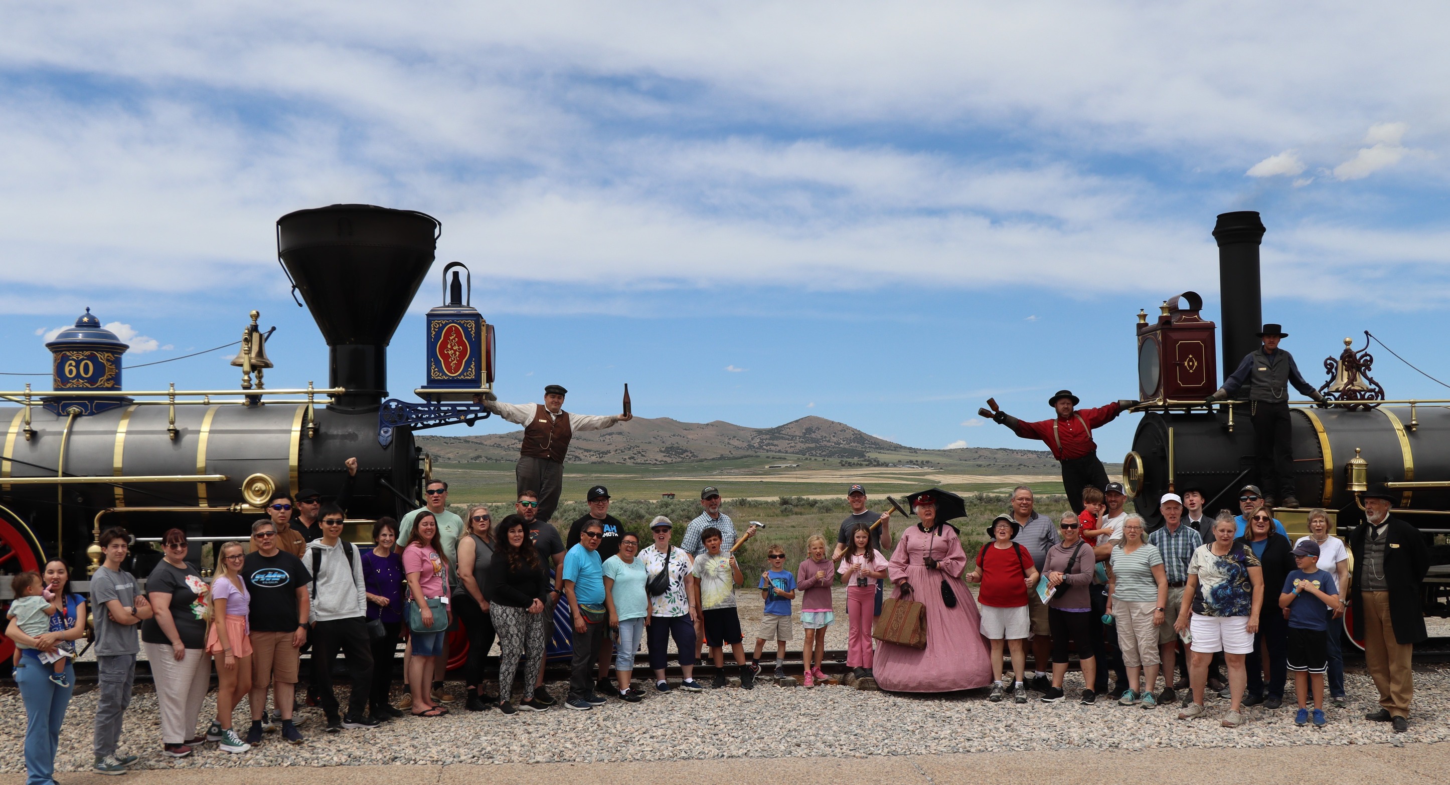 Locomotive staff and visitors gather around two locomotives to recreate the Champagne Photo