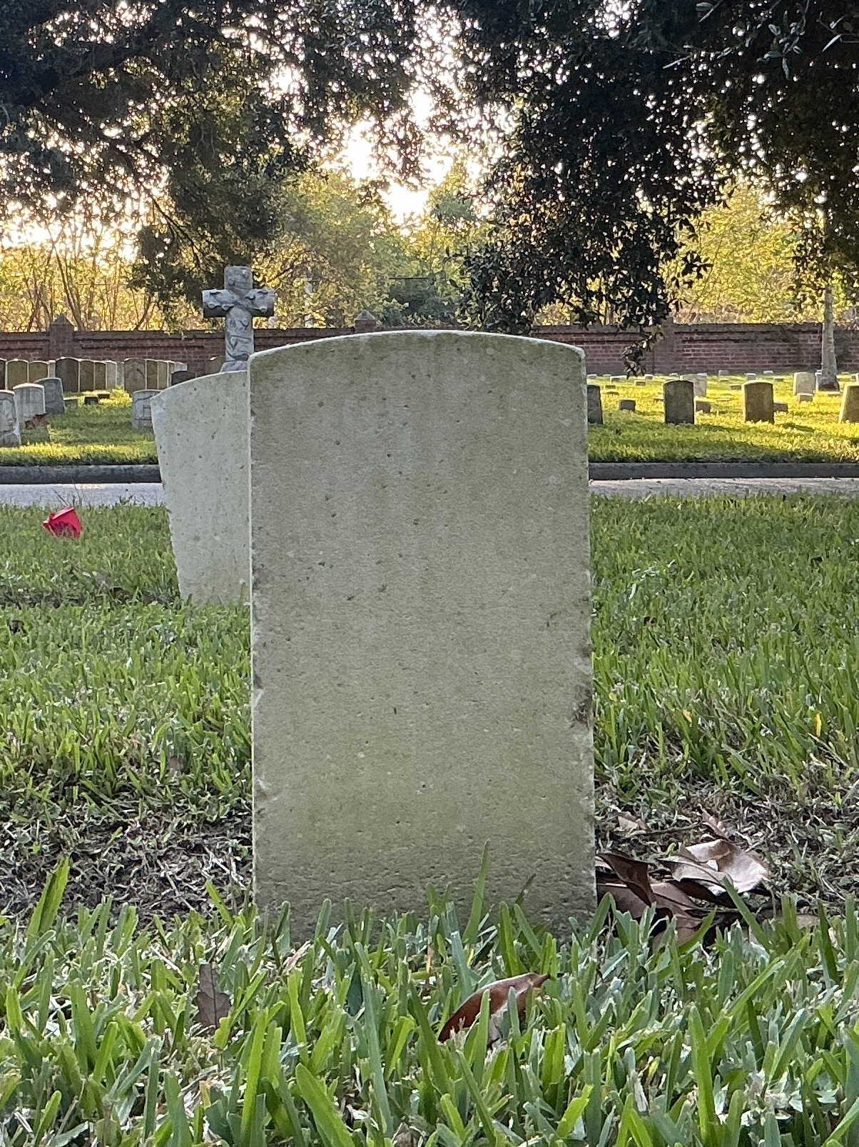 Back of historic upright marble headstone with recessed shield face.