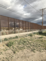A fence with a chain link fence in the background.