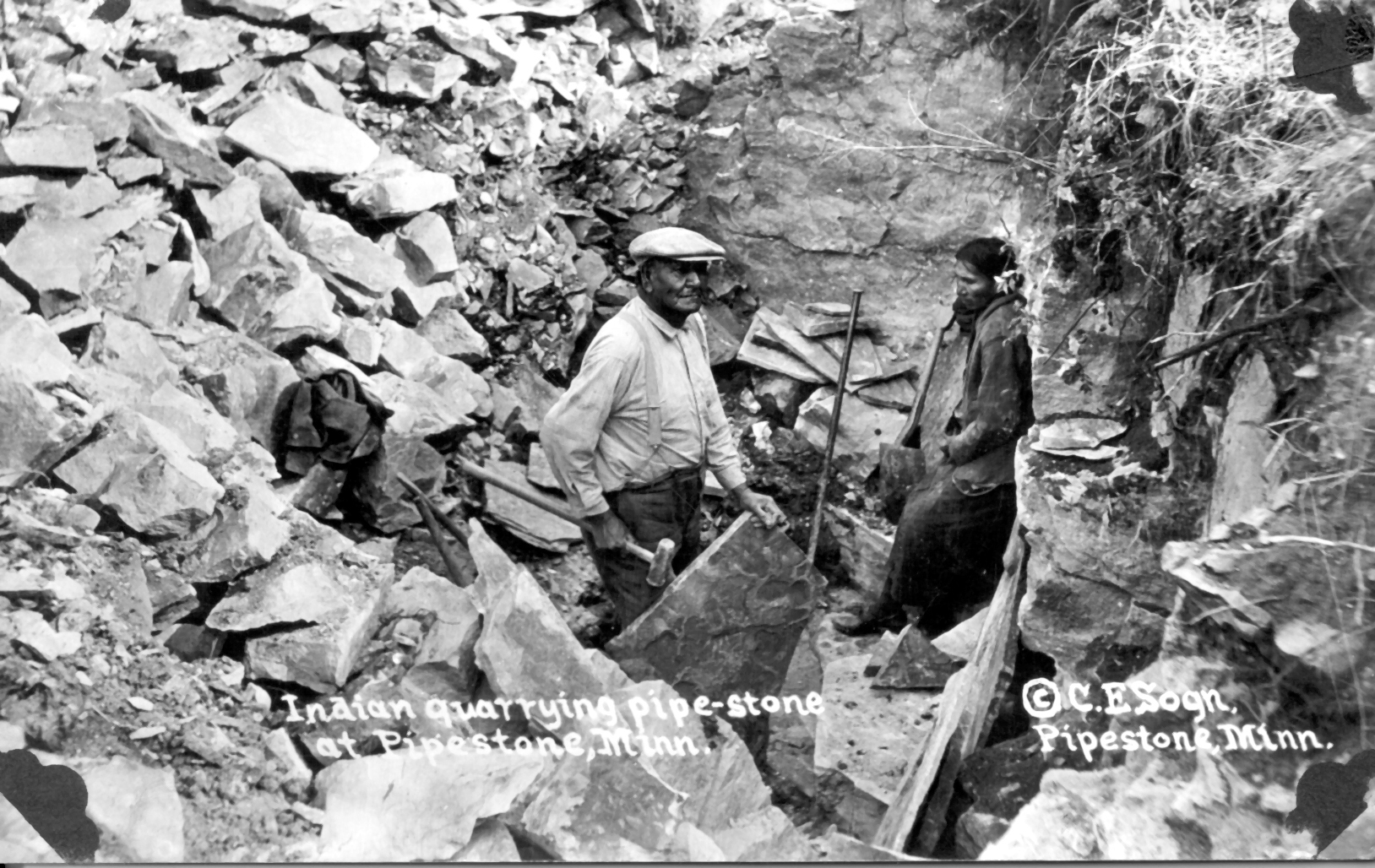 2 men surrounded by rocks in a quarry pit