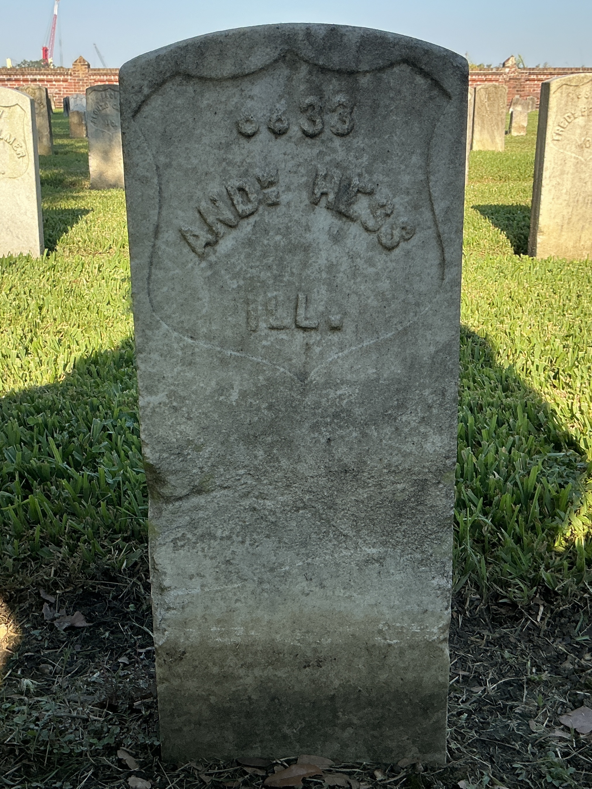 Front of historic upright marble headstone with recessed shield face.