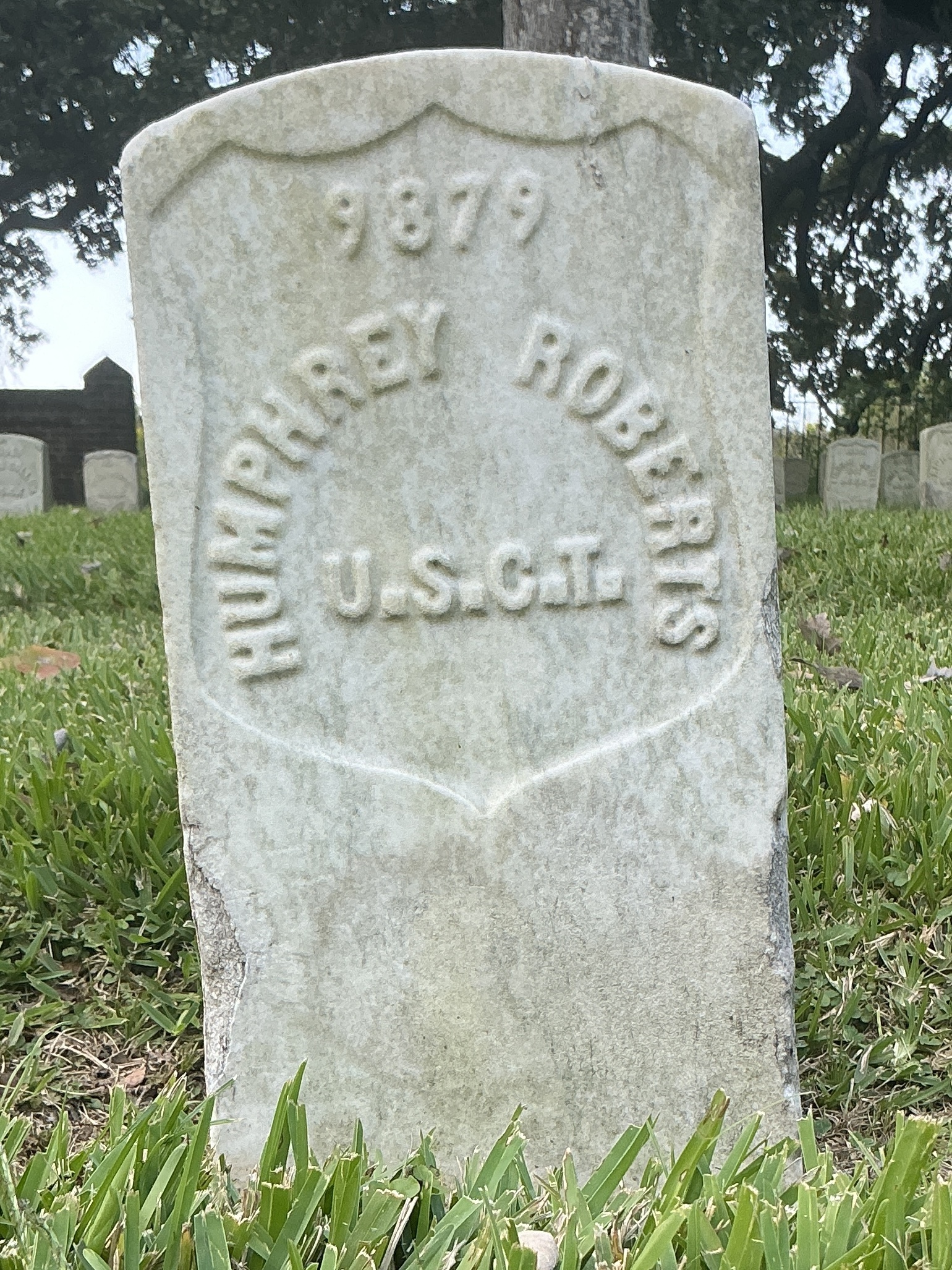 Front of historic upright marble headstone with recessed shield face.