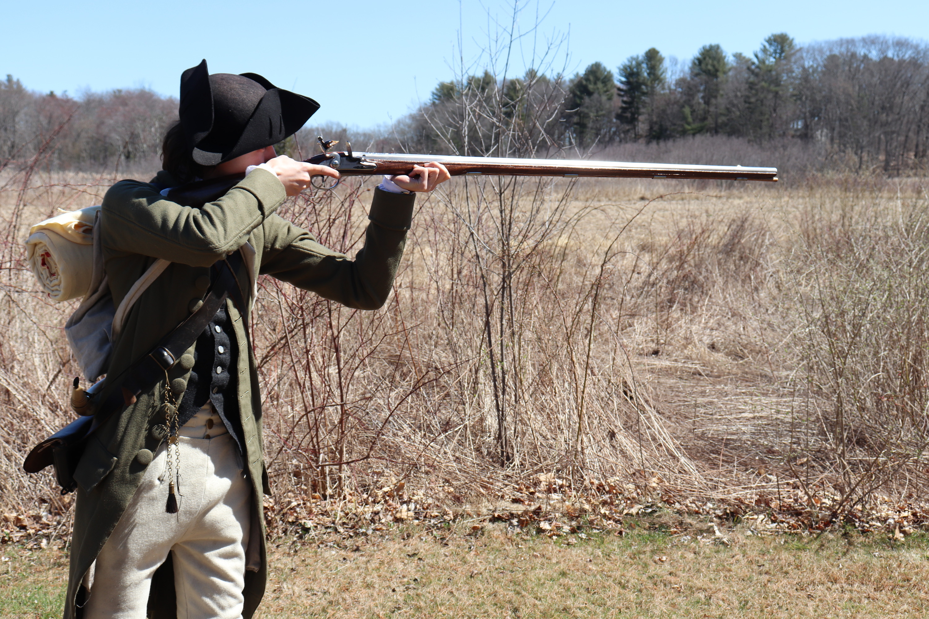 Park Ranger in colonial clothing aiming musket
