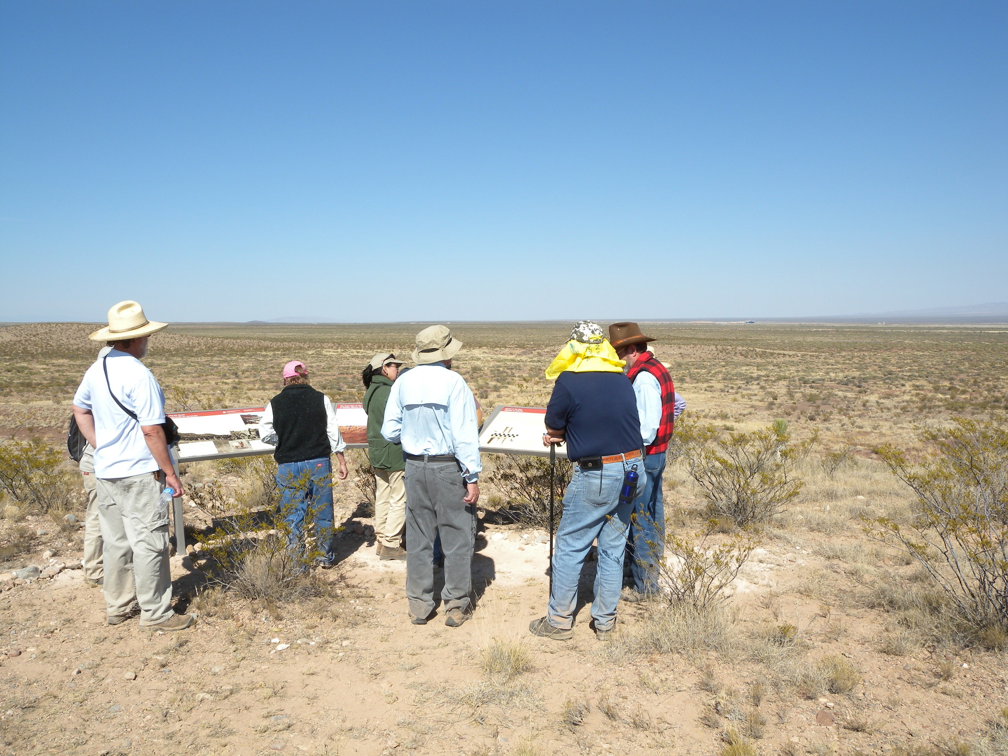 A group of people looking at something in the desert.