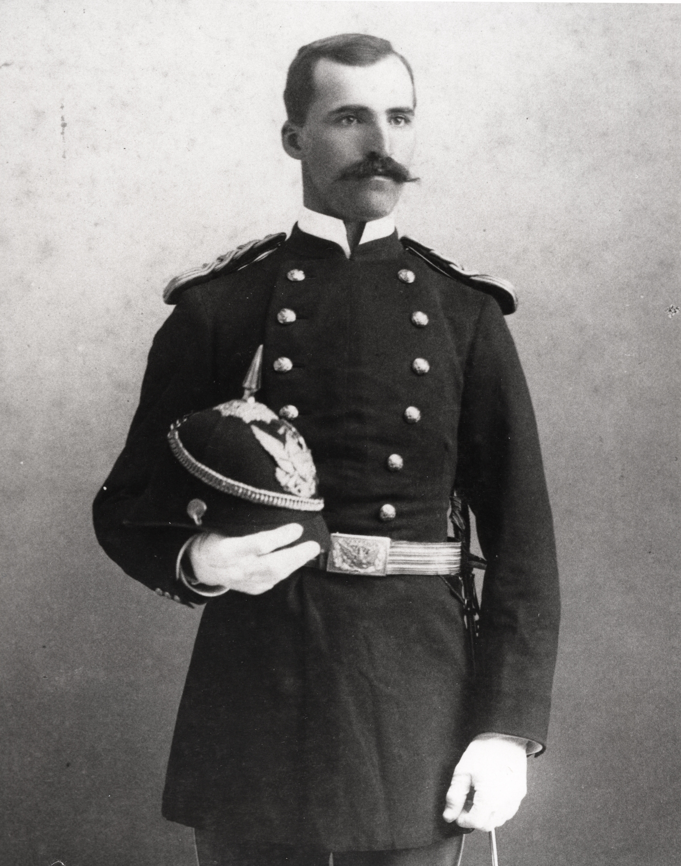Black and white photograph of a man in a military uniform standing for a photograph