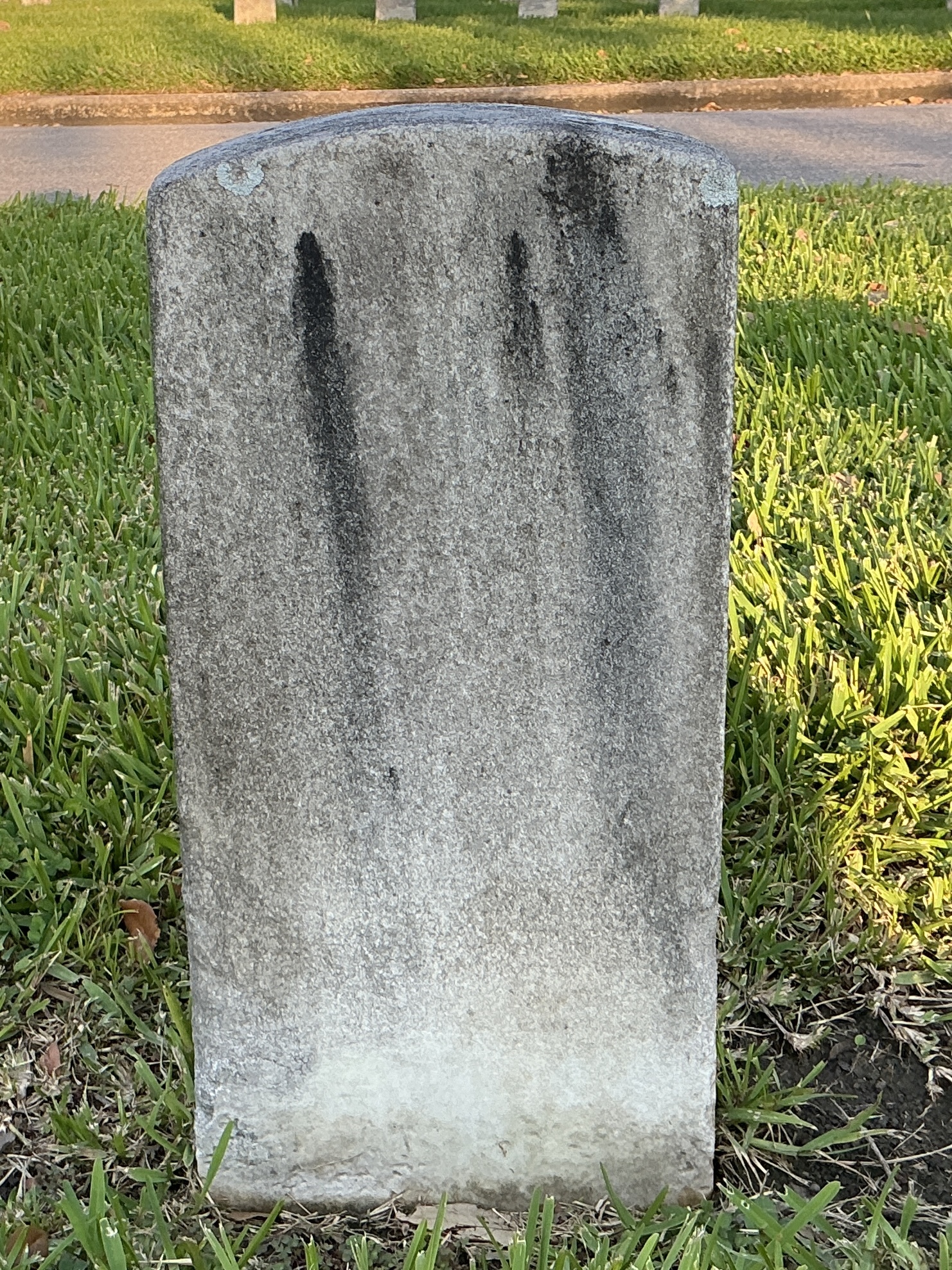 Back of historic upright marble headstone with recessed shield face.