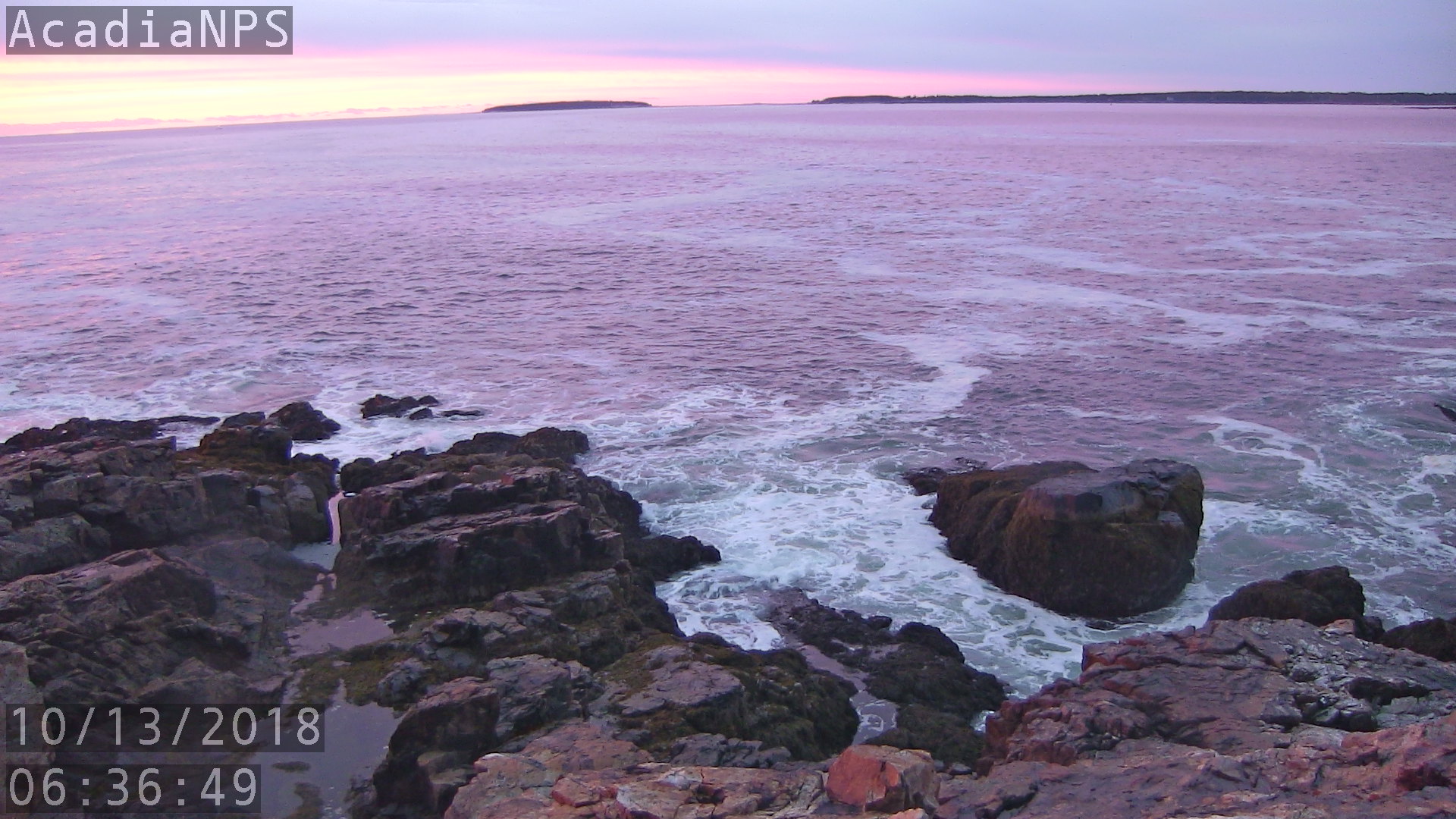 Pink reflections across open ocean at sunrise