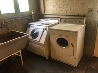 Historic washer, drier, and sink in a basement