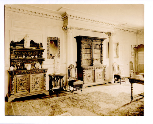 Black and white photograph of large 19th century library, with Renaissance revival bookcases.