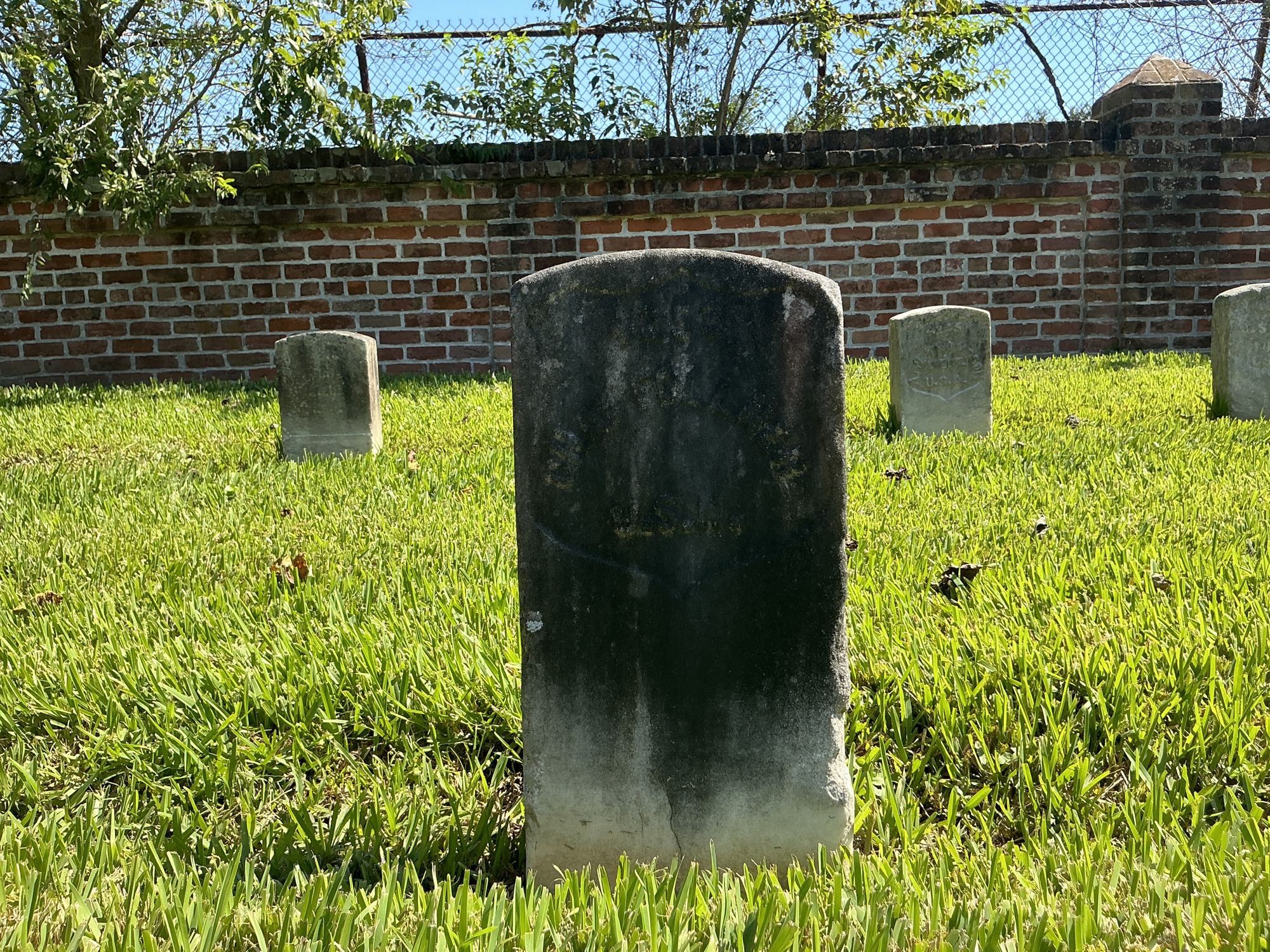 Front of historic upright marble headstone with recessed shield face.