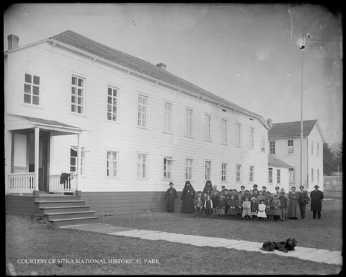 Adults and children outside the Russian Bishop's House with Bishop Innocent.