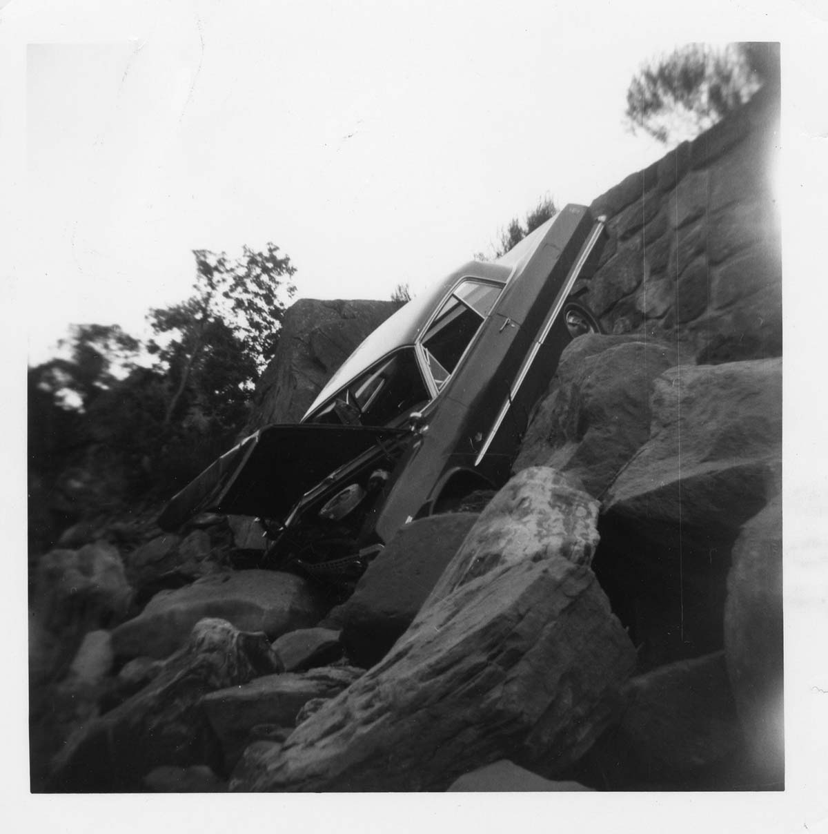 BW photo of a car that went off the road into the Virgin River.