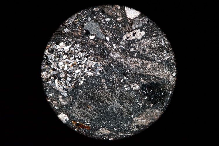 Circular microscopic image of rock structure.