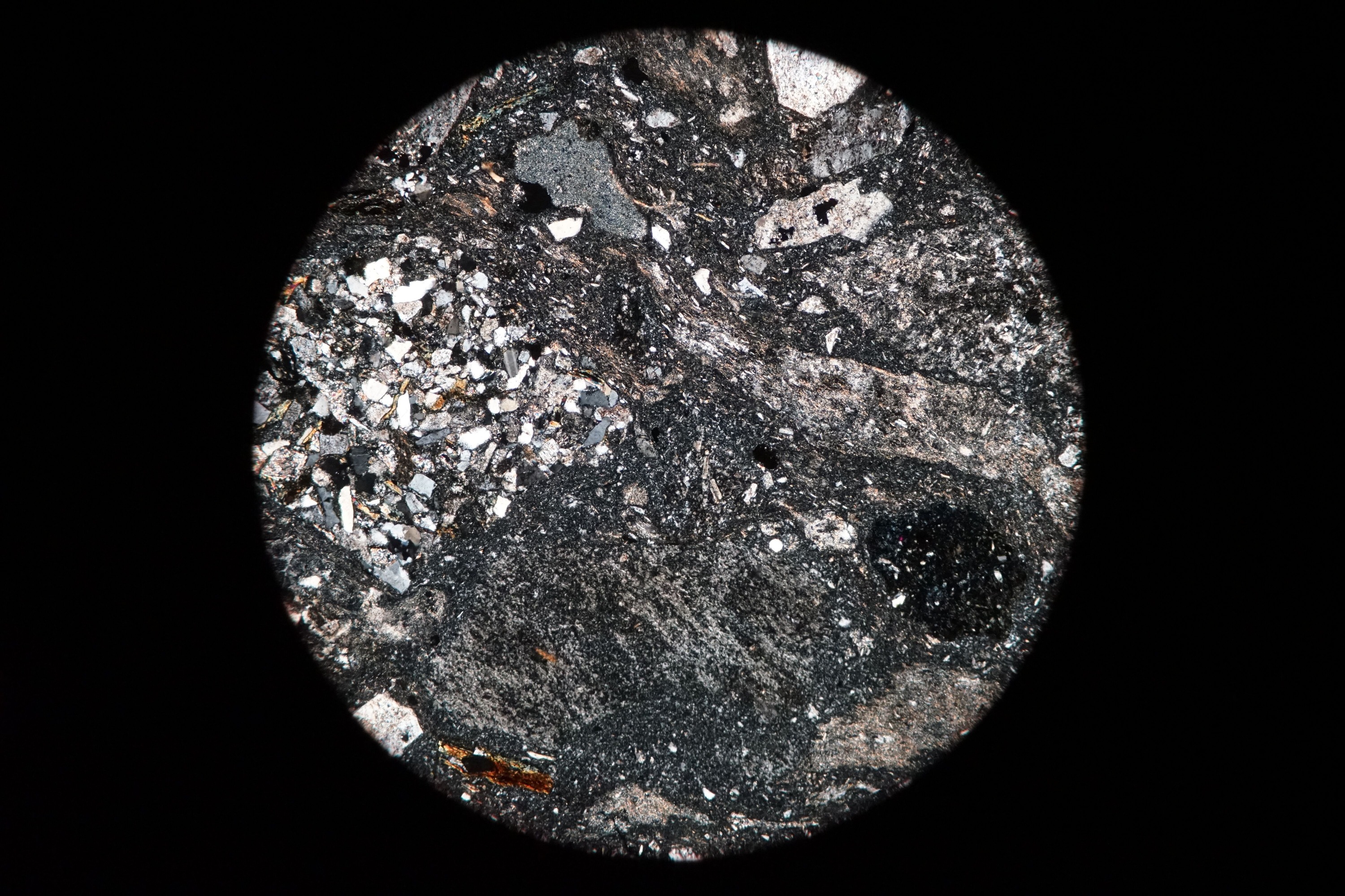 Circular microscopic image of rock structure.