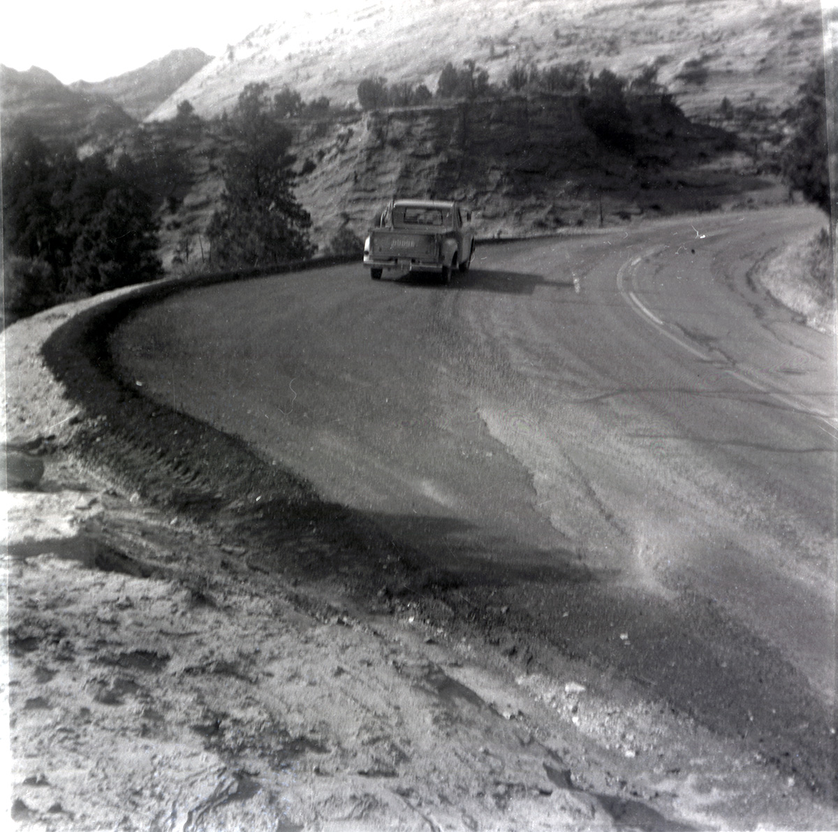 Truck driving down the road during east side road repair and turn out construction.