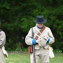 Confederate guard holding a canteen, a large circular water container.